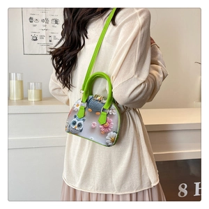 Detailed close-up of 3D floral owl applique on a green mesh shell bag with leather trim