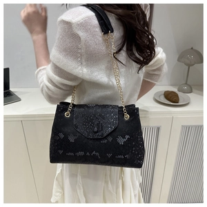 Detail of black snakeskin pattern shoulder bag with a premium golden chain strap