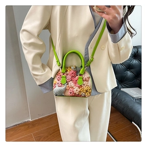 Detailed view of floral shell bag with 3D embroidery and cute elephant pattern design