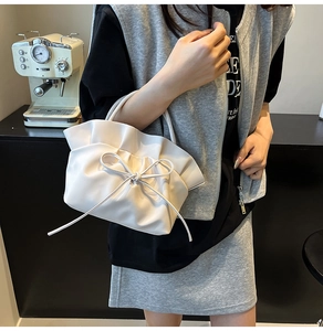 Detail of white cloud-shaped handbag with leather bow and pleated soft PU texture