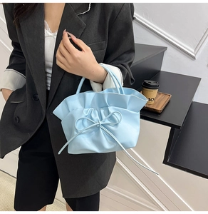 Détail du sac nuage plissé bleu clair orné d'un délicat nœud en cordon de cuir souple