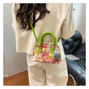 Detail of floral knit shell handbag featuring 3D crochet flowers and fish pattern