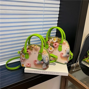 Detail of 3D floral elephant embroidery on green shell bags with dual zipper and strap
