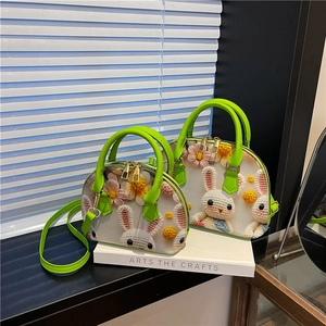Detail of floral shell bags with 3D crochet rabbits and vibrant green handles
