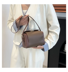 Detail of vintage box bag with brown lychee pattern leather and metallic twist lock closure