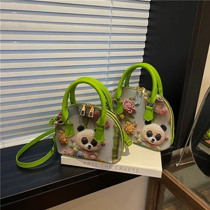 Detailed macro of shell bags with 3D floral panda embroidery and bright green handles