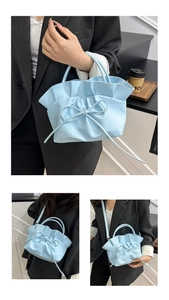 Vue détaillée du sac bleu clair à plis avec nœud décoratif et poignée fine