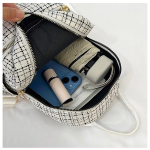 Vue intérieure du mini sac à dos en tweed montrant le rangement du parapluie et du mobile