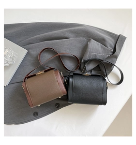 Detail view of large-capacity crossbody bags in brown and black pebbled leather texture
