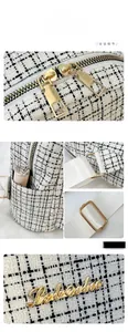 Détail du sac à dos en tweed noir et blanc avec fermetures dorées et poche latérale à rouge à lèvres
