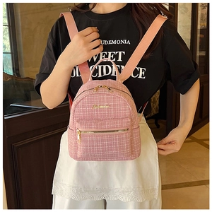 Gros plan d'un sac à dos en tweed rose avec fermetures éclair dorées et bretelles
