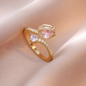 Bague tulipe dorée élégante avec pierre de zircon rose sur fond de soie champagne