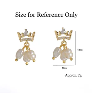 Boucles d'oreilles couronne dorées avec perles d'eau douce et zircons sur fond blanc