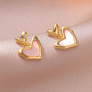 Vintage pink heart drop earrings with gold floral details on champagne silk fabric background