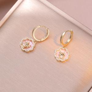Detail of vintage flower earrings with pink enamel, dragon motif, and white pearl inlay