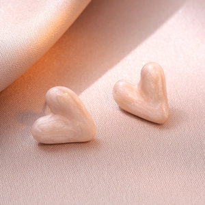 Minimalist pink heart stud earrings with marble texture on pink satin background