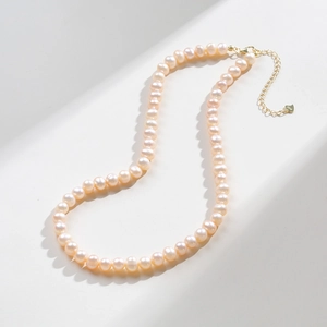 Natural freshwater pearl necklace with S925 silver clasp and heart charm on white background
