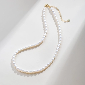 Detail of S925 silver gold-plated lobster clasp and heart tag on a pearl necklace