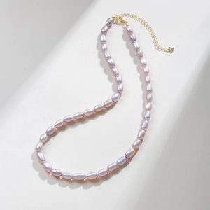 Macro view of lavender freshwater pearl necklace with golden clasp and adjustable chain