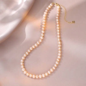 Detail of pink freshwater pearl necklace with S925 silver heart clasp on silk fabric
