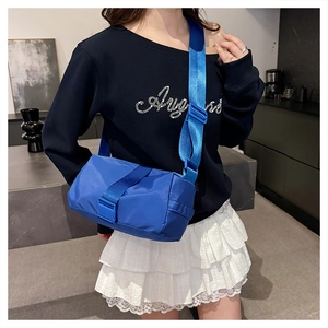 Detail of blue nylon crossbody bag with adjustable wide strap and buckle closure