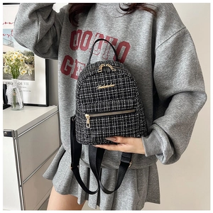 Vue détaillée du mini sac à dos en tweed noir et blanc avec des zips dorés élégants
