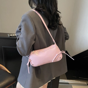 Borsa a spalla rosa con borchie, dettagli a fiocco e finiture in metallo argentato