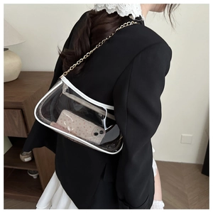 Detail of transparent PVC shoulder bag with white trim and golden chain strap