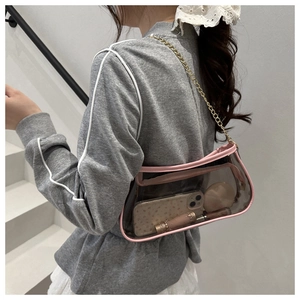 Clear pink shoulder bag with gold chain showing storage space for phone and makeup