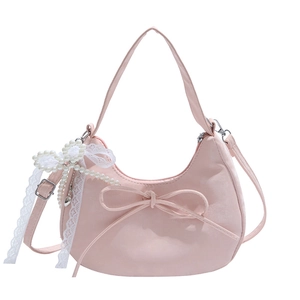 Sac sous le bras rose en demi-lune avec nœud décoratif et pendentif perle sur fond blanc