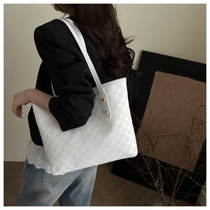 White woven quilted tote bag with large capacity shown being worn in a minimalist setting