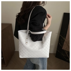 Minimalist white tote bag with quilted texture shown on shoulder for daily commute