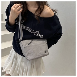 Detailed view of gray functional crossbody bag with nylon texture and zipper pockets