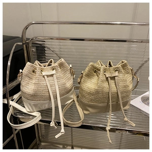 Close-up of straw bucket bags with leather trim and drawstring detail in soft light