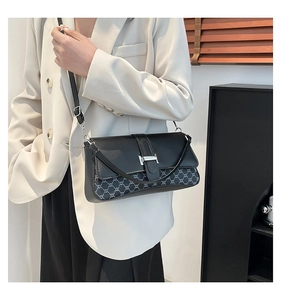 Close-up of retro black baguette bag with silver hardware and gray patterned panels