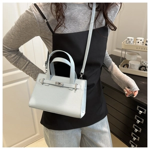 Light blue pebbled leather handbag with crossbody strap shown on model for size and style