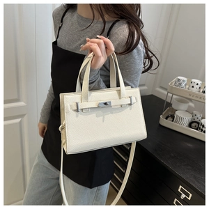 Detail of white lychee pattern leather bag with silver buckle and detachable strap