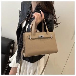 Detail of lychee pattern leather handbag with silver twist lock and crossbody strap