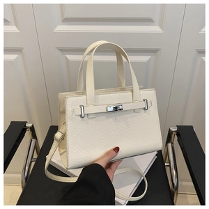 Detailed view of cream white lychee grain leather handbag with silver metallic twist lock