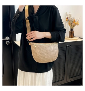 Detail of woven texture and adjustable wide strap on the beige crescent crossbody bag