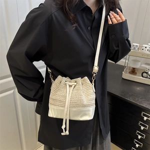 Japanese style woven straw bucket bag with white leather patchwork and drawstring closure