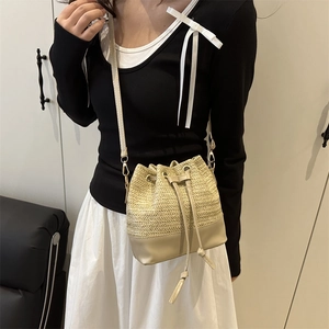 Japanese style woven straw bucket bag with leather base and drawstring closure