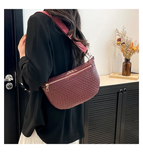 Detail of burgundy woven crossbody bag with pink strap and metallic zipper closure