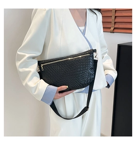 Detail of black woven crescent bag with gold zipper and adjustable nylon strap