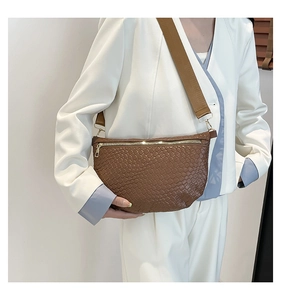 Brown woven texture crossbody bag detail with adjustable strap and gold metal zipper
