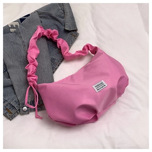Detail of pink nylon tote bag featuring a pleated strap and FASHION woven label