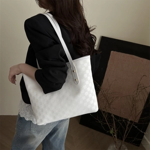 White woven textured tote bag with minimalist shoulder strap for fashion commute