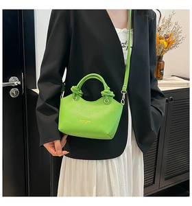 Detail of green litchi grain leather tote bag with gold hardware and hand strap