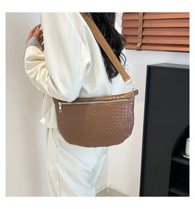 Close-up of brown woven PU leather crossbody bag with golden zipper and adjustable strap