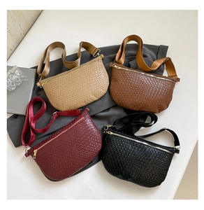 Flat lay of four woven leather crossbody bags in beige, brown, burgundy, and black
